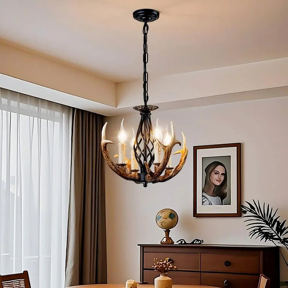 Antler chandelier with warm glow, illuminating a modern rustic dining room with wooden furniture and framed art.