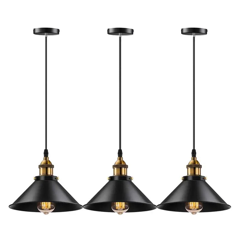 Three industrial farmhouse pendant lights in black with brass accents, hanging in a row against a white background.