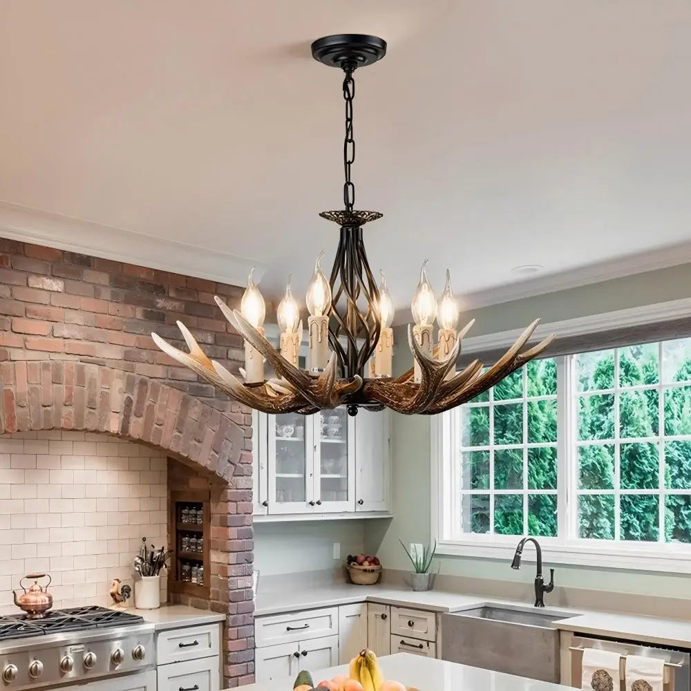 Large antler chandelier as a focal point in a spacious kitchen with brick accents and white cabinets.