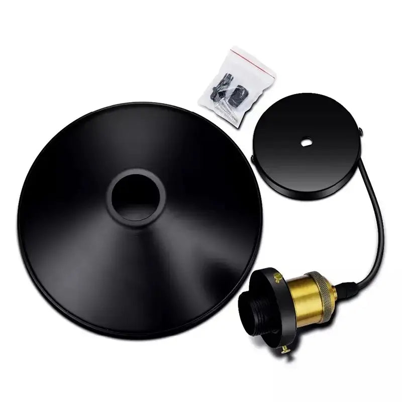 Disassembled components of a black metal pendant light: cone shade, ceiling plate, cord, and brass lamp holder with small hardware bag.