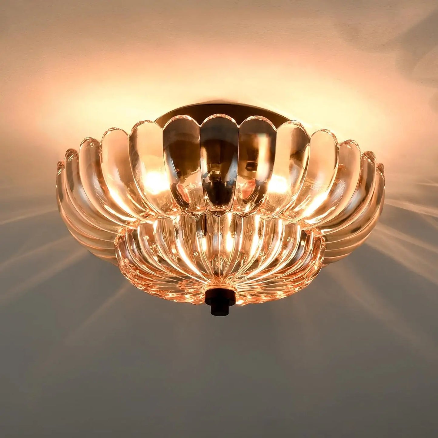 Flush mount ceiling light with amber glass glowing warmly, creating elegant reflections on the ceiling