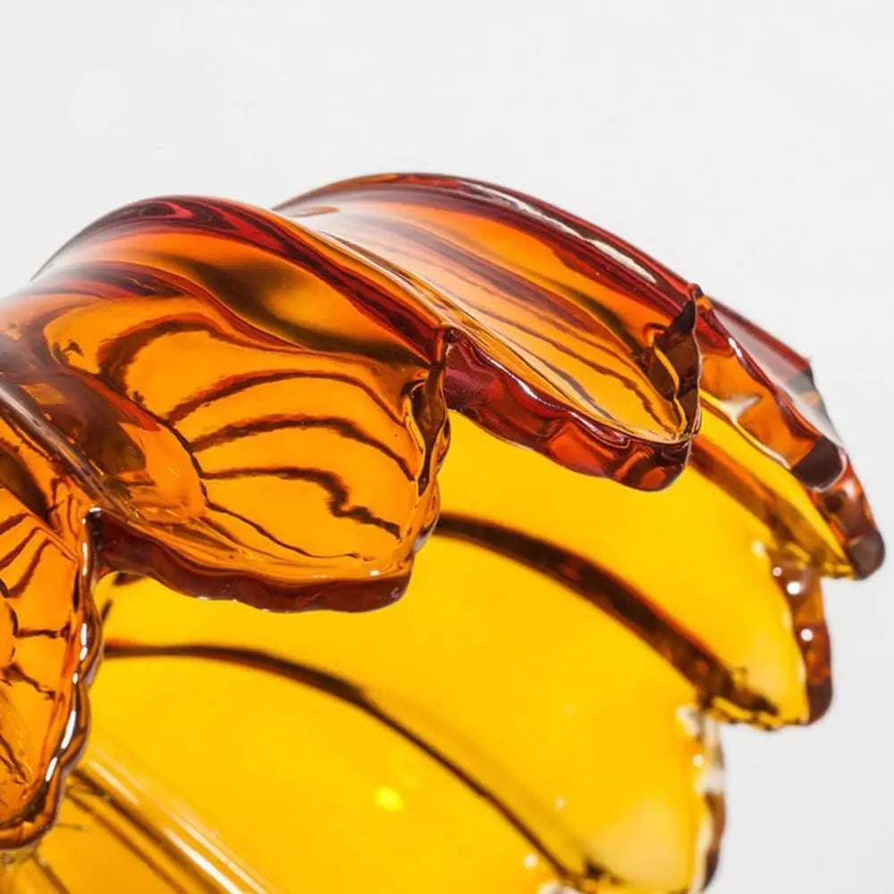 Angled close-up of the amber glass pendant light shade, emphasizing the unique scalloped design and spiral texture.