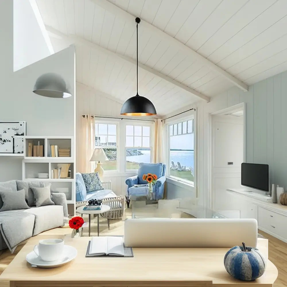 Black dome pendant light with gold interior illuminating a cozy and bright living room with a coastal theme.