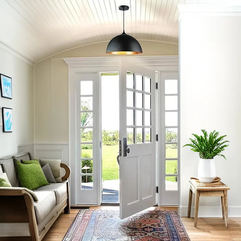 Black and gold dome pendant light in an entryway, providing a welcoming and modern aesthetic to the home.