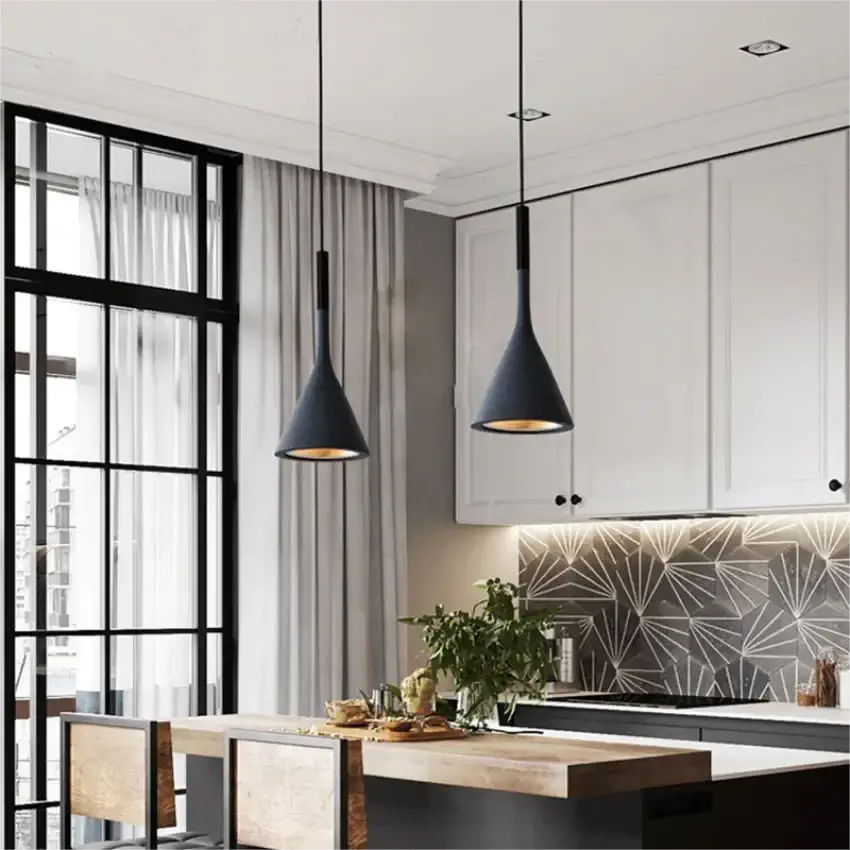 Two sleek black minimalist pendant lights hanging over a stylish kitchen island with white cabinets and geometric tile backsplash, ideal for modern kitchens.
