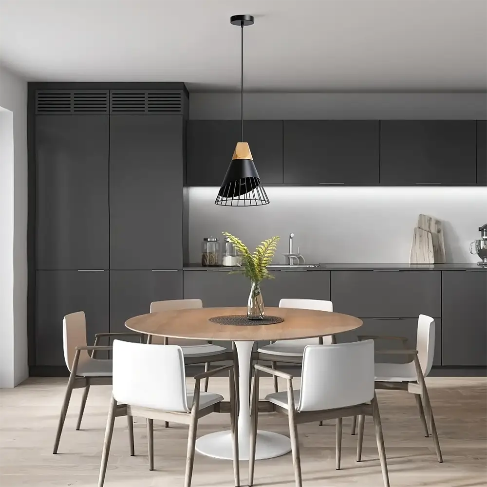 Black minimalist pendant light with a wooden top hanging above a round dining table in a sleek, modern kitchen.
