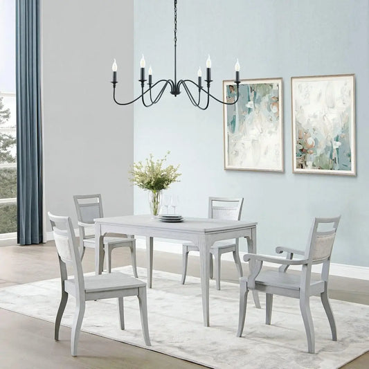 A black 6-light chandelier hanging above a light-colored dining table and gray chairs in a contemporary dining room.