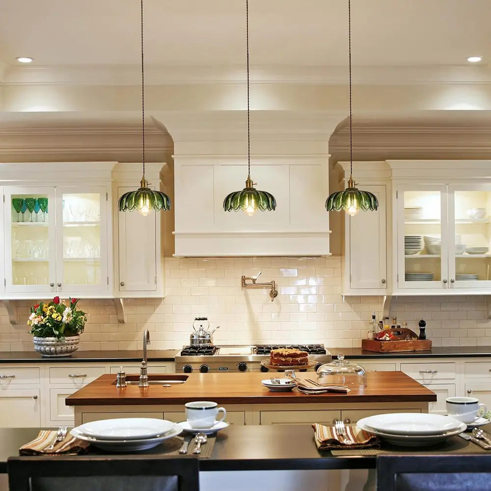 A full view of the green fluted glass pendant light, showing the decorative braided cord and the light it casts.