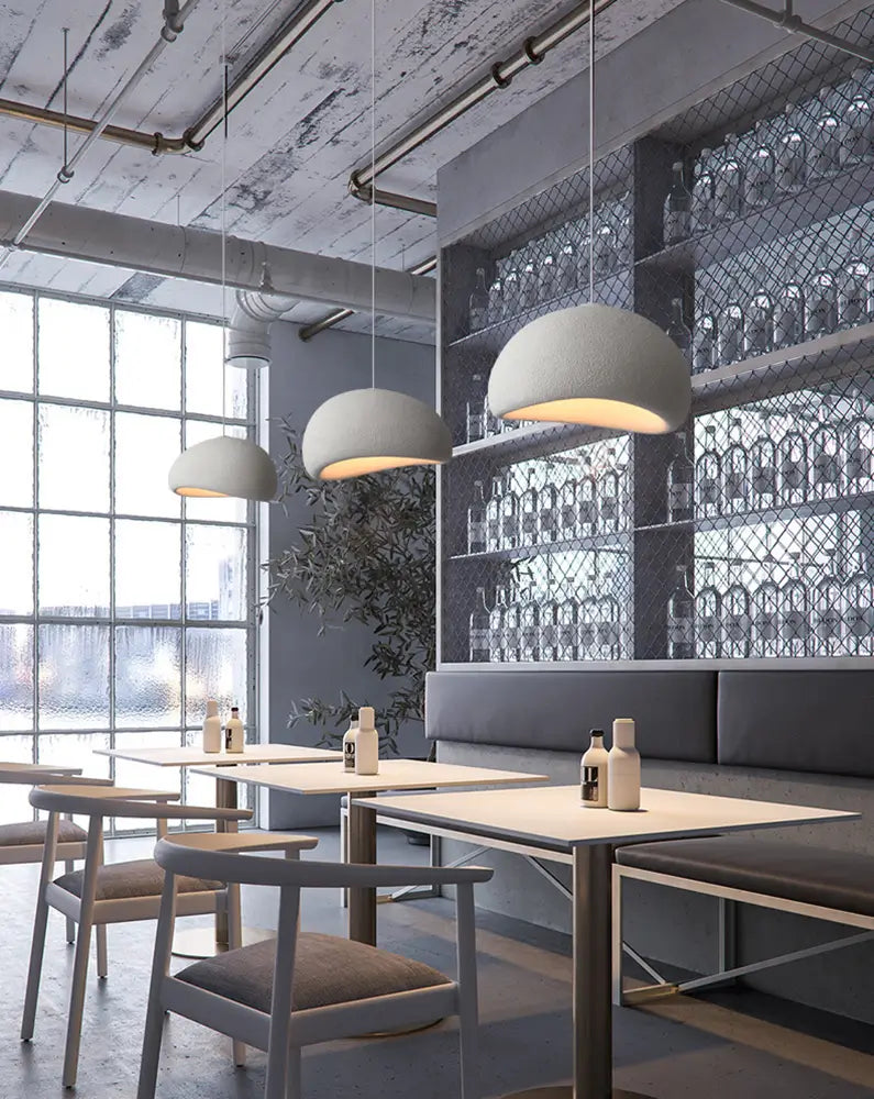 Industrial restaurant space with modern stone-finish pendant lighting.