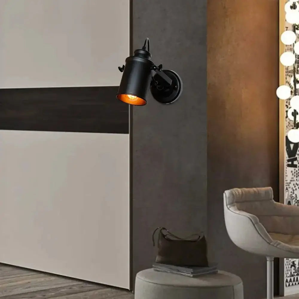 Modern black wall sconce light fixture mounted on a bedroom wall, creating a warm and cozy ambiance.