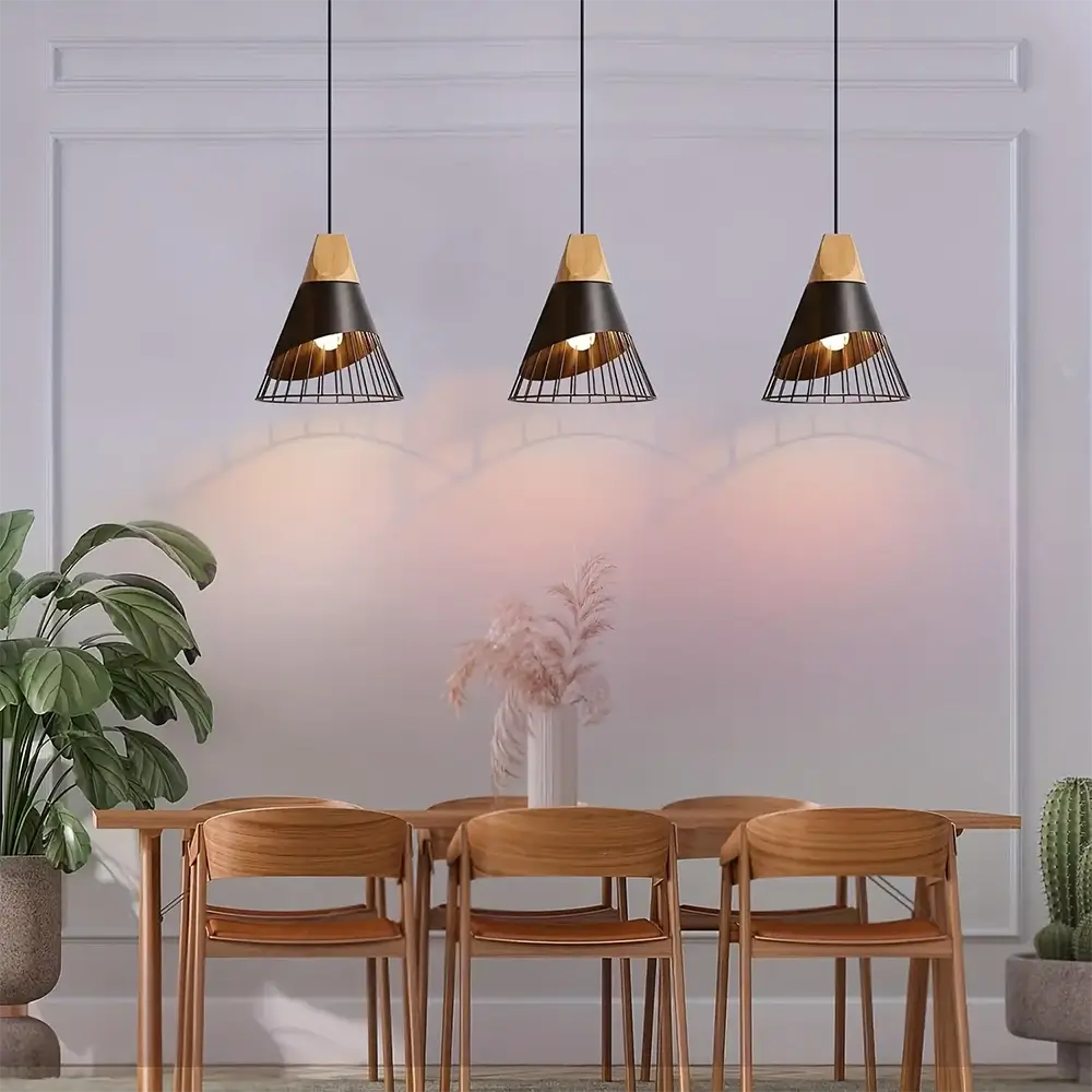 Three Scandinavian-style black pendant lights hanging above a wooden dining table in a modern dining room.