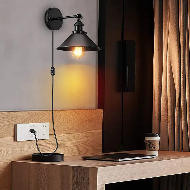 Modern industrial plug-in wall lamp installed in a cozy bedroom setting.
