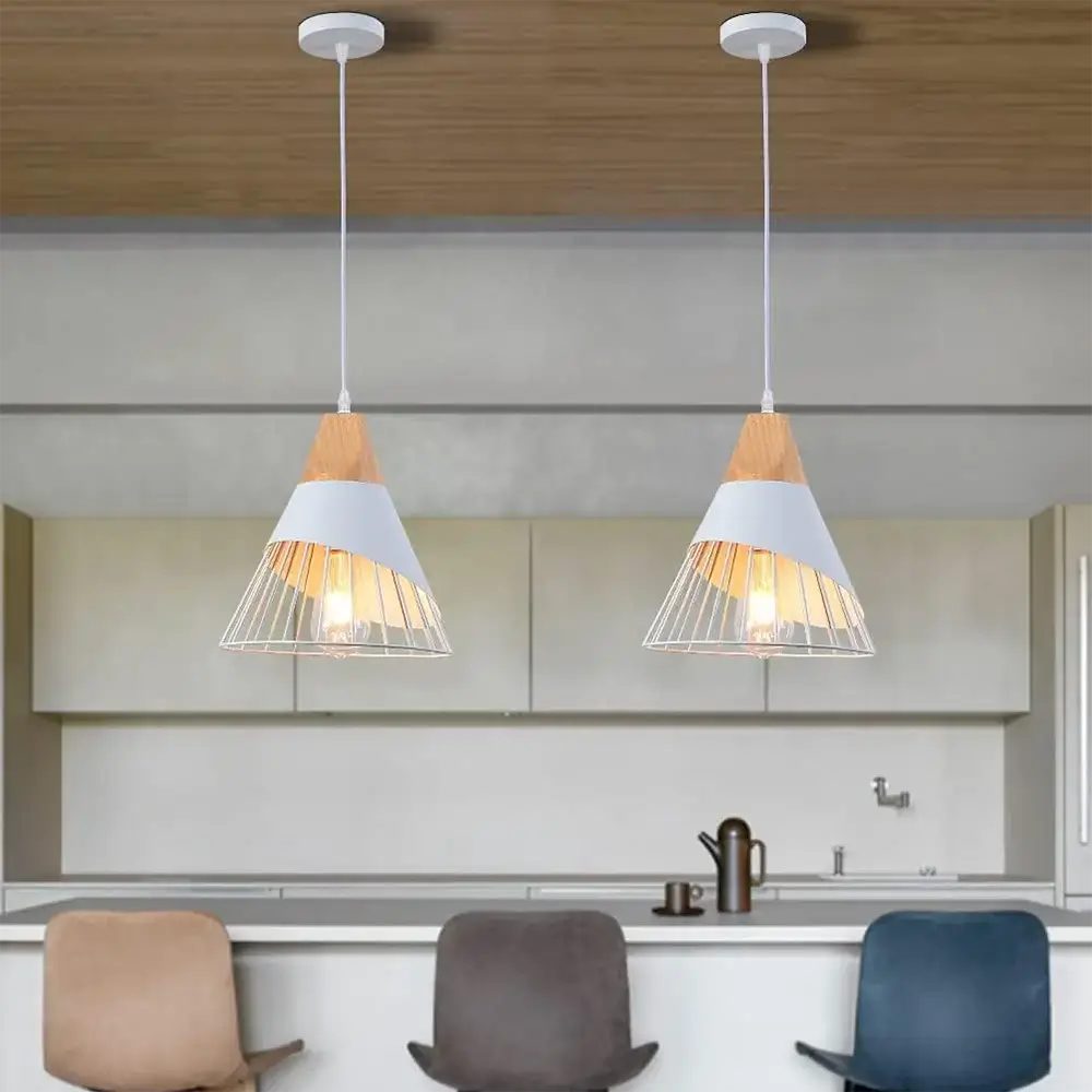 Two white and wood pendant lights hanging above a modern kitchen island with bar stools.