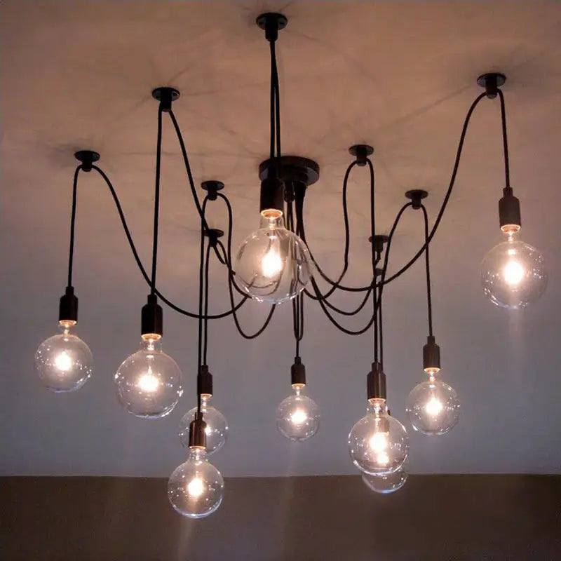 A modern loft chandelier with clear globe bulbs, highlighting a black multi-arm pendant light with a central black fixture and multiple clear glass bulbs illuminating a room with a light-colored ceiling.