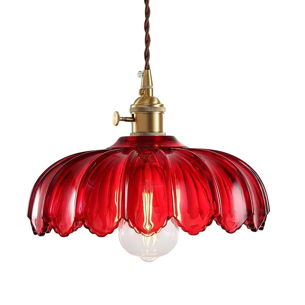 A close-up of a vintage-style red glass pendant light with a fluted and scalloped shade, showcasing the brass hardware.