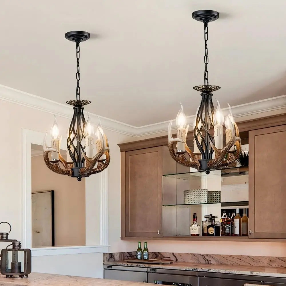Rustic antler chandelier hanging over kitchen island with vintage bar decor, perfect for farmhouse lighting style