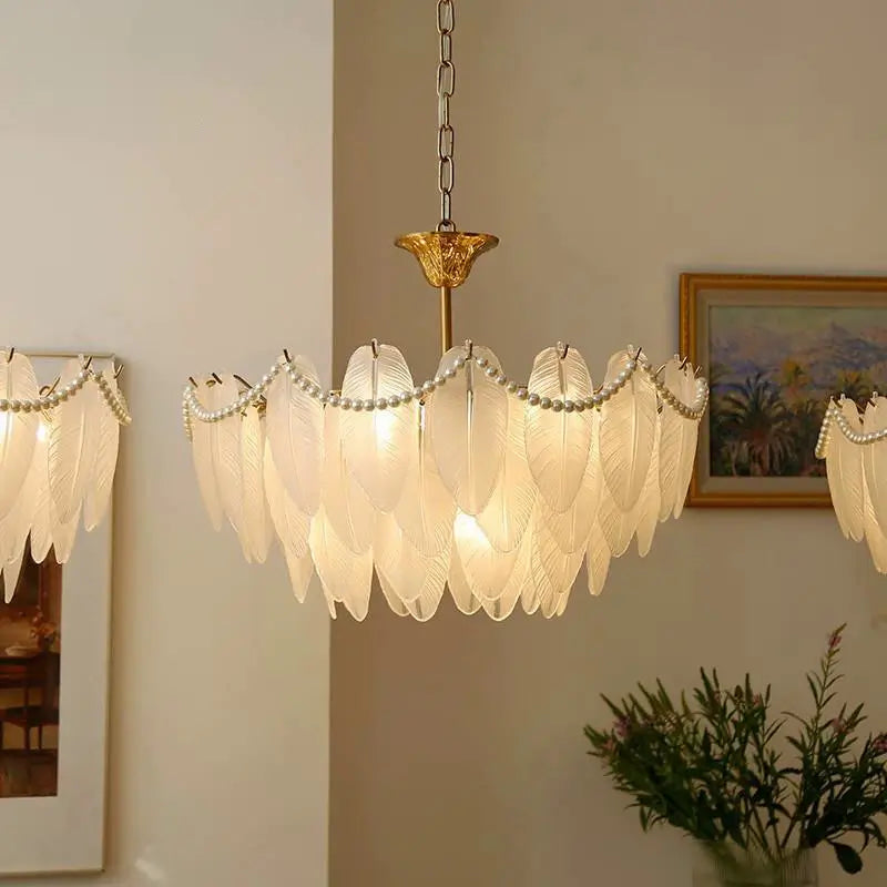 Warm illuminated vintage-style glass feather chandelier, providing soft lighting suitable for dining and living rooms.