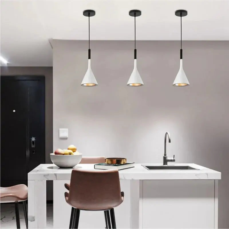 Three clean white minimalist pendant lights over a bright kitchen island with an integrated sink, perfect for contemporary kitchen and dining areas.