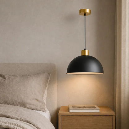 30 cm black dome pendant light installed beside a bed above a wood nightstand.