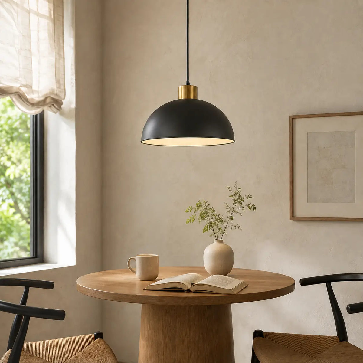 30 cm black dome pendant light above a round wood table in a bright breakfast nook.