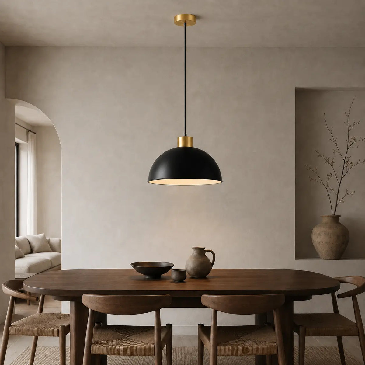 30 cm black dome pendant light installed above a wood dining table in a warm neutral dining room.