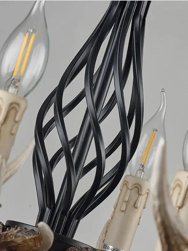 Detailed view of the chandelier's black metal frame and candle-shaped LED bulbs, highlighting the intricate design.