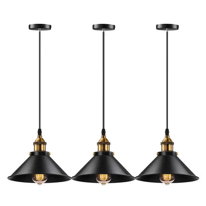 Three industrial farmhouse pendant lights in black with brass accents, hanging in a row against a white background.