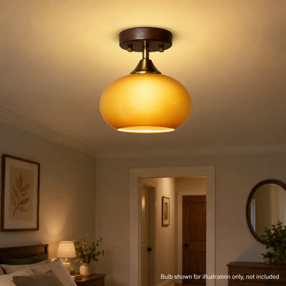 Amber glass ceiling light illuminated above a bedroom doorway at night