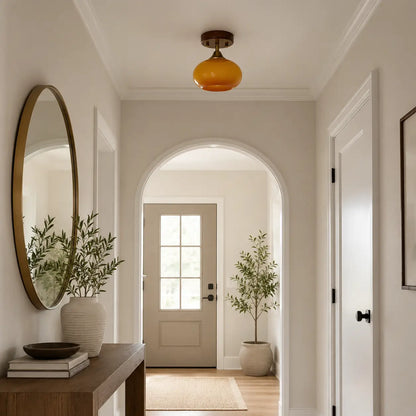 Amber glass semi-flush ceiling light installed above an entryway console table