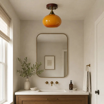 Amber glass ceiling light installed above a powder room vanity and mirror