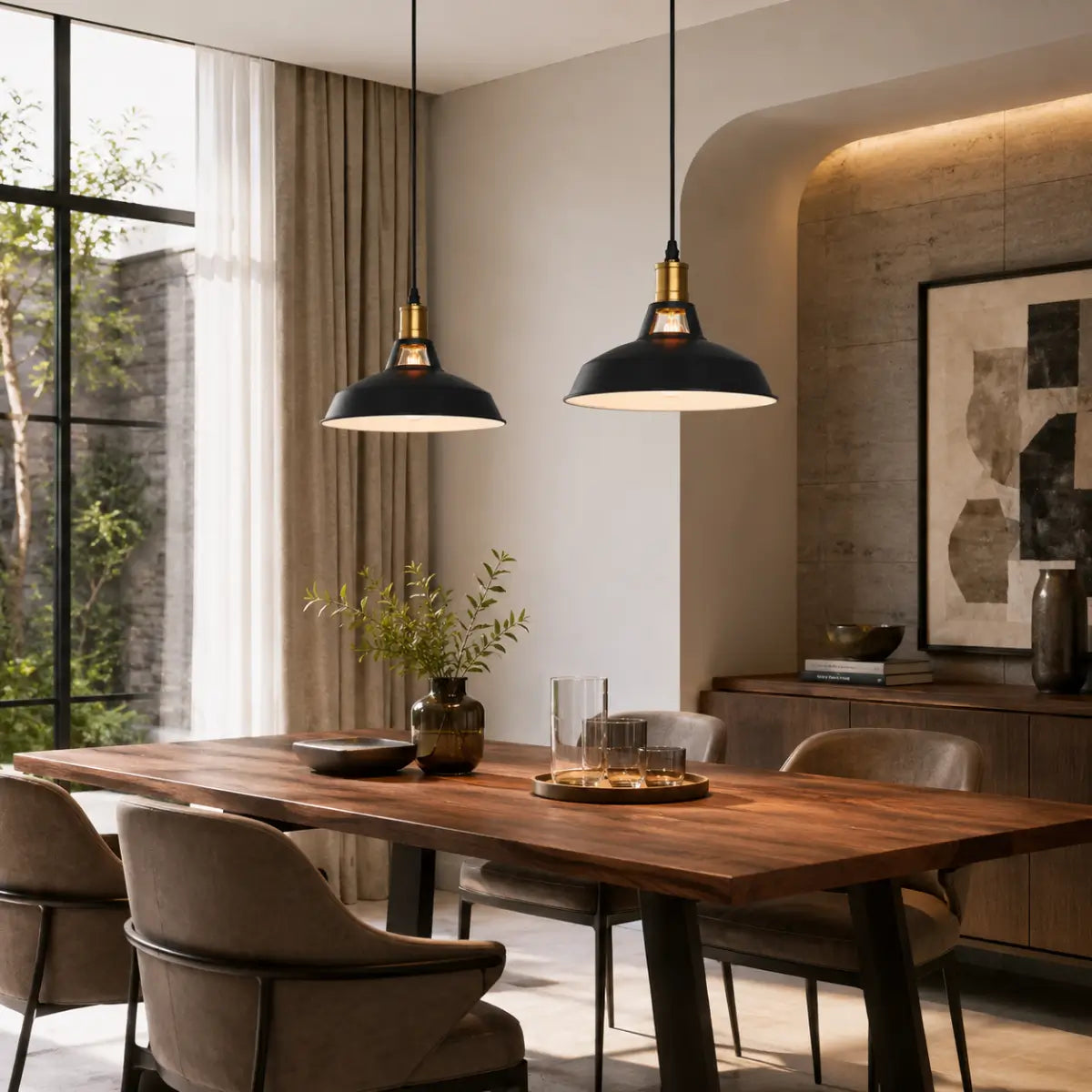 Two matte black dome pendant lights hanging above a wood dining table in a warm modern dining room.
