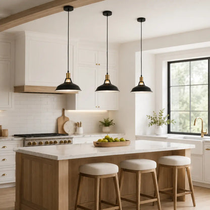 Three black dome pendant lights installed above a wood and white kitchen island.