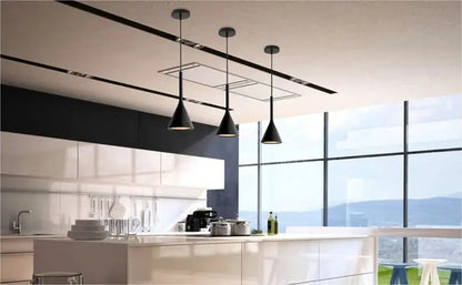 hree black minimalist pendant lights suspended over a clean, modern kitchen island with white cabinets and large windows, ideal for open-plan living.