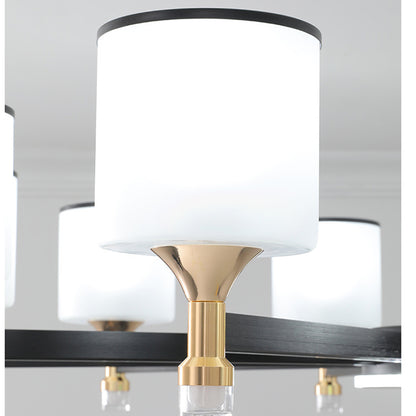 the white chandelier lampshade rests on a gold base