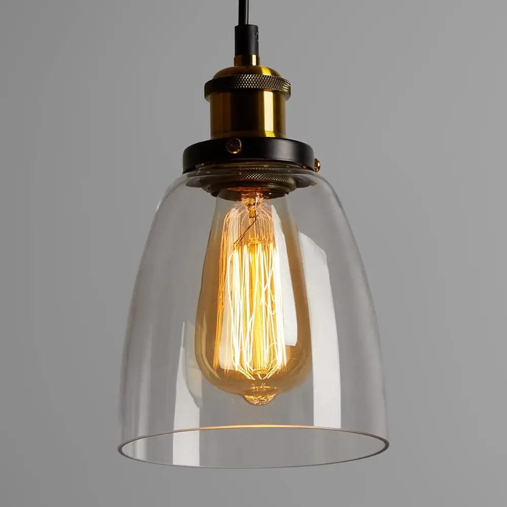 Close-up view of a single vintage glass pendant light with an Edison-style bulb inside the clear bell-shaped shade.