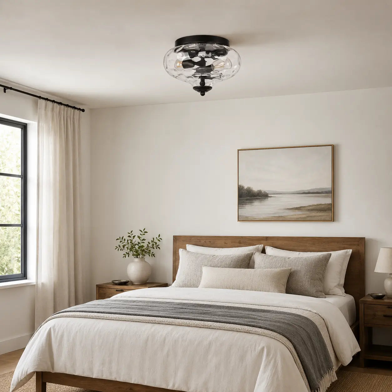 Black flush mount ceiling light installed above a neutral-toned bedroom with a wood bed frame and nightstands.