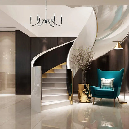 An elegant black 6-light chandelier positioned in a grand entryway with a modern spiral staircase and stylish decor.
