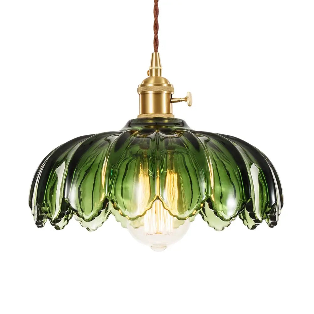 A detailed shot of a vintage-style green fluted glass pendant light with a scalloped design, showcasing its vibrant color.