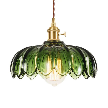 A detailed shot of a vintage-style green fluted glass pendant light with a scalloped design, showcasing its vibrant color.
