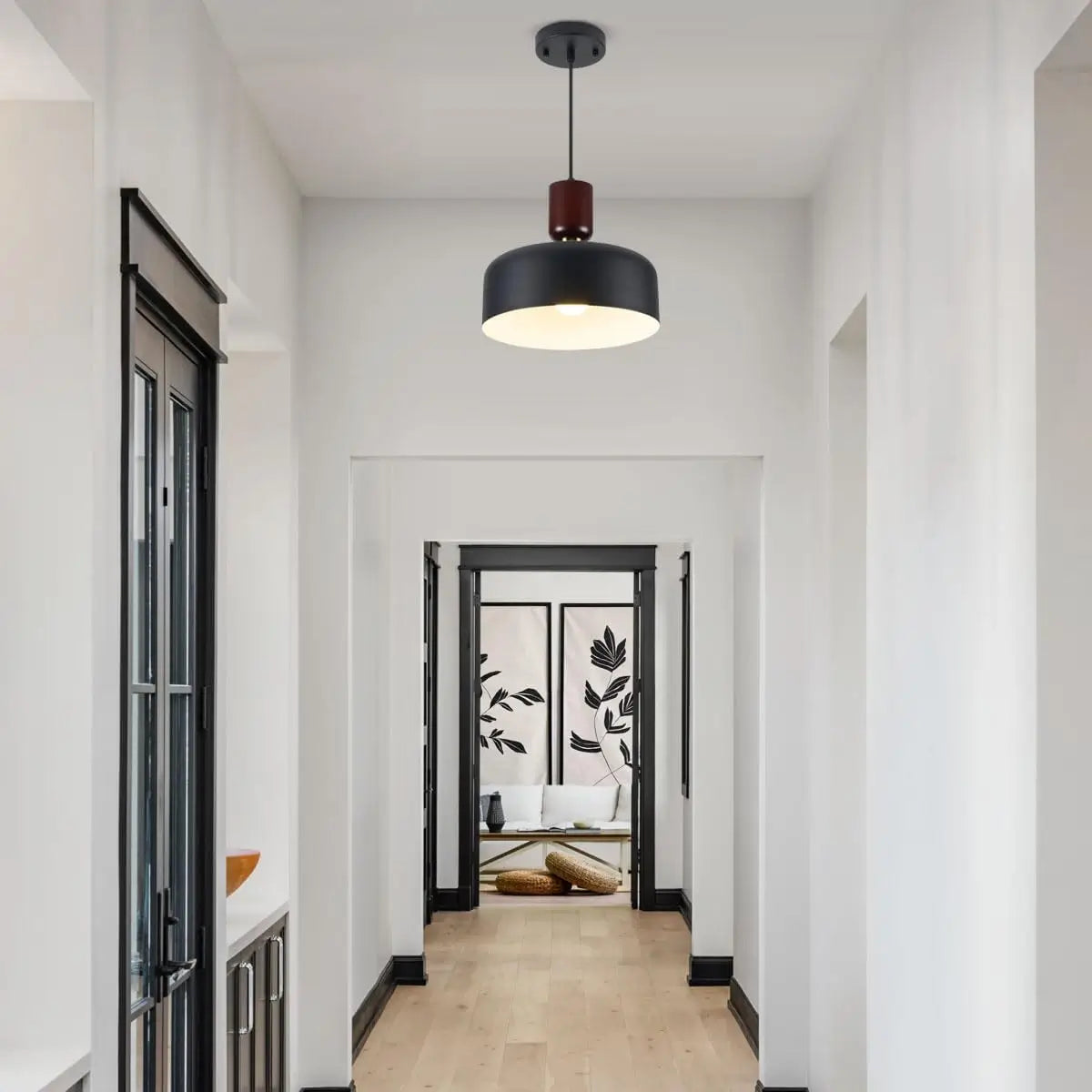 Black pendant light illuminating a minimalist hallway with modern decor