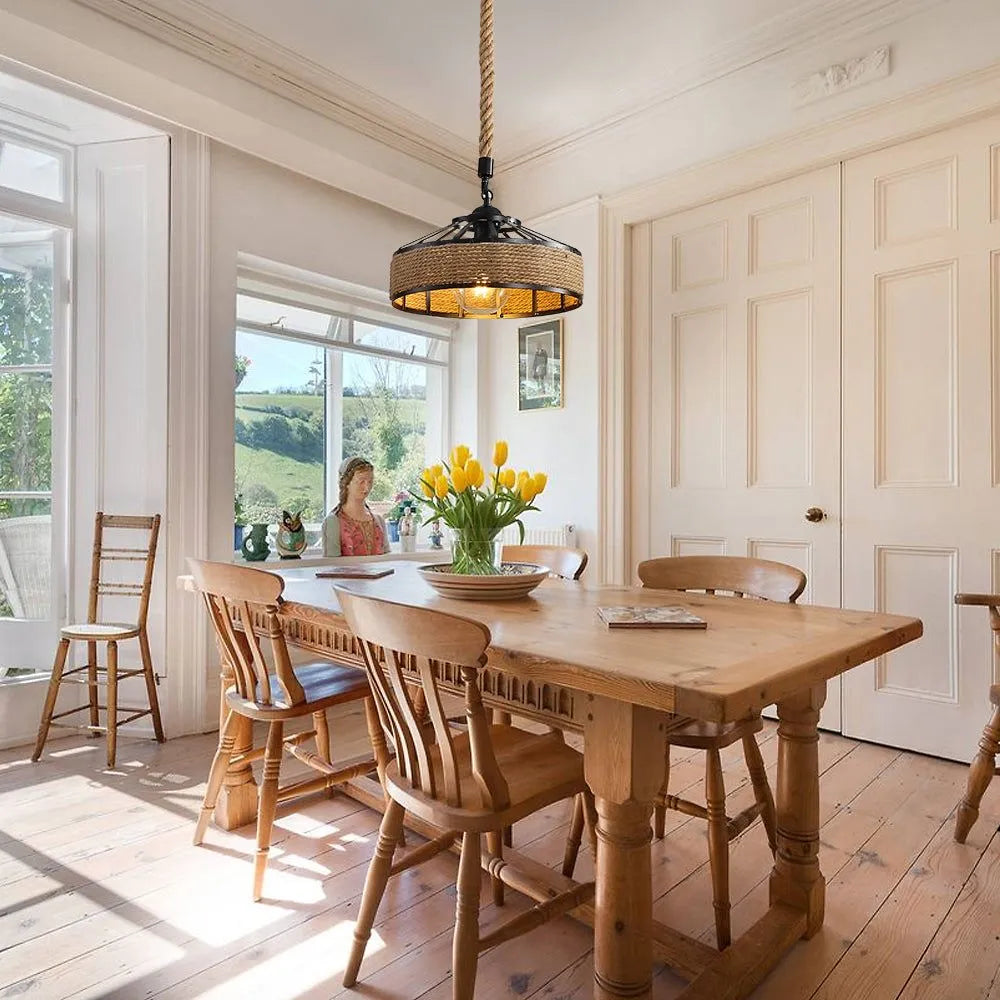 A pendant light with a black circular frame wrapped around a brown hemp rope hangs above the dining table