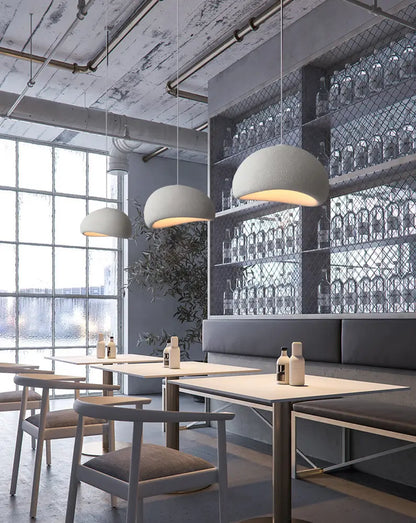 Industrial restaurant space with modern stone-finish pendant lighting.