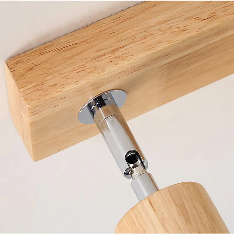 Close-up detail of the metal and wood joint of the adjustable ceiling lamp