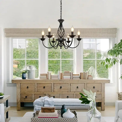 Black rustic farmhouse chandelier enhancing a cozy living room with natural wood furniture and large windows, perfect for home decor.