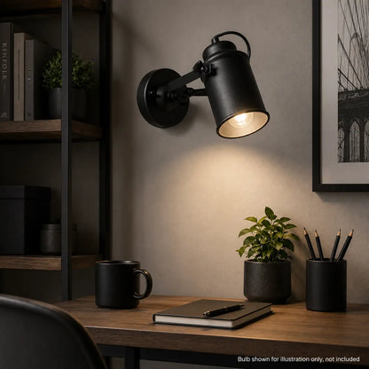 Matte black directional wall sconce installed above a home office desk