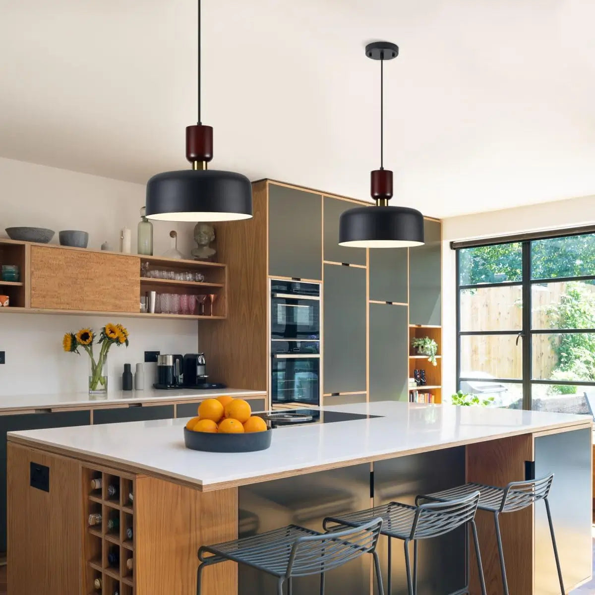 Pair of black pendant lights above a modern kitchen island with wooden cabinets