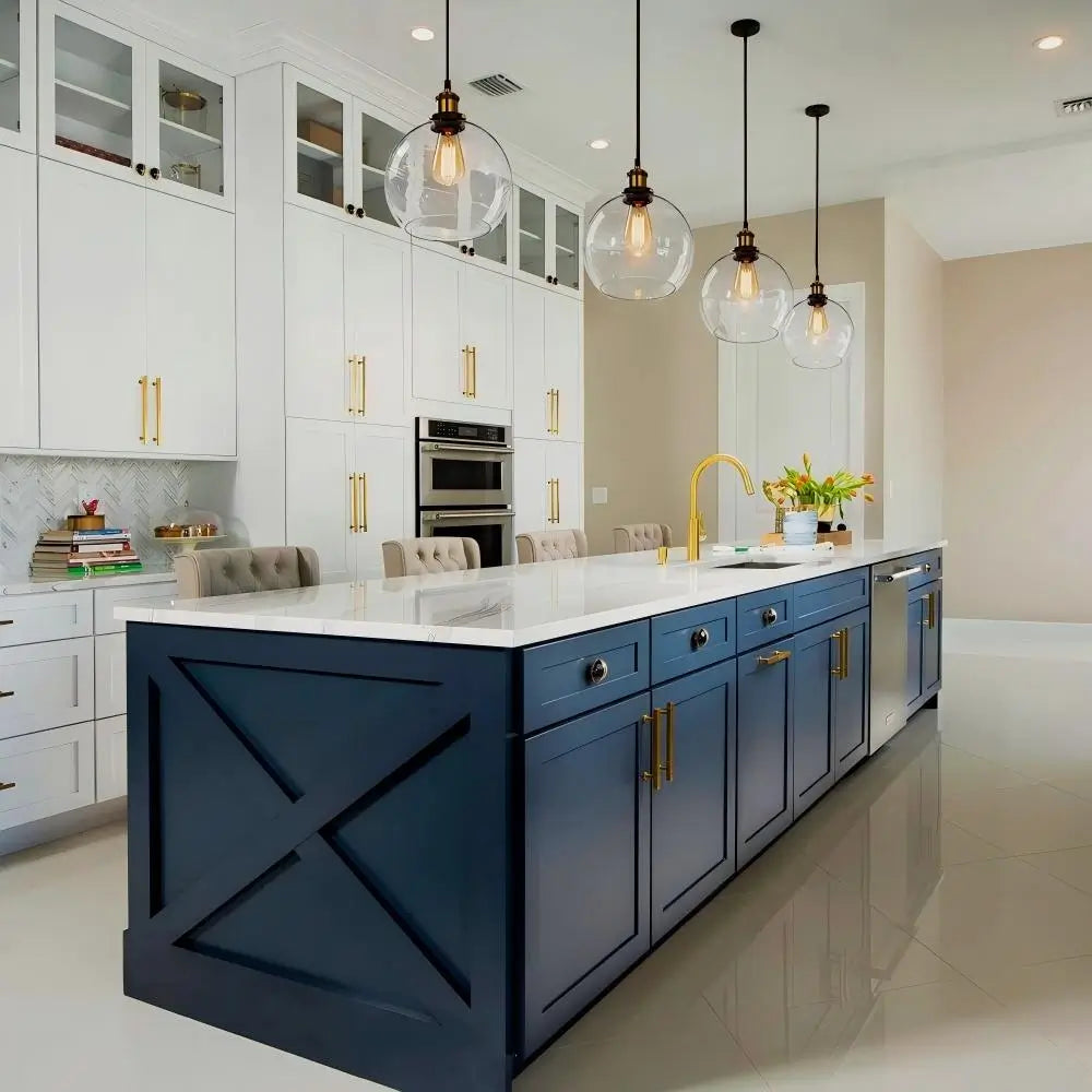 Modern kitchen with a large island illuminated by three clear glass globe pendant lights.