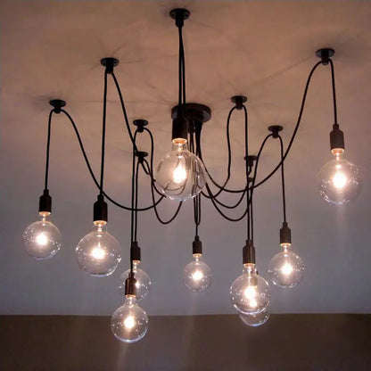 A modern loft chandelier with clear globe bulbs, highlighting a black multi-arm pendant light with a central black fixture and multiple clear glass bulbs illuminating a room with a light-colored ceiling.