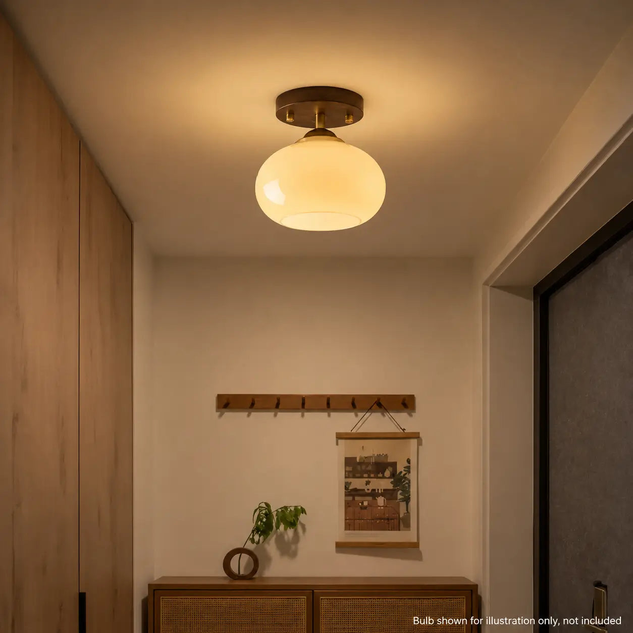 Opal glass ceiling light illuminated in a hallway near a wood cabinet