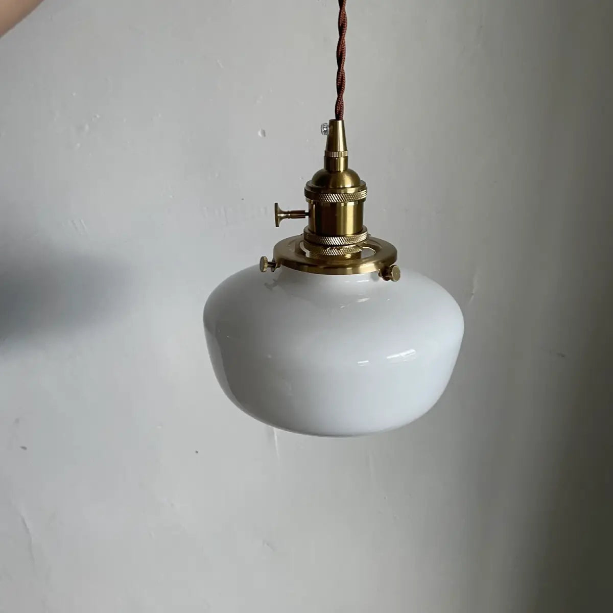 Milk glass pendant light hanging at full length showing cord and canopy